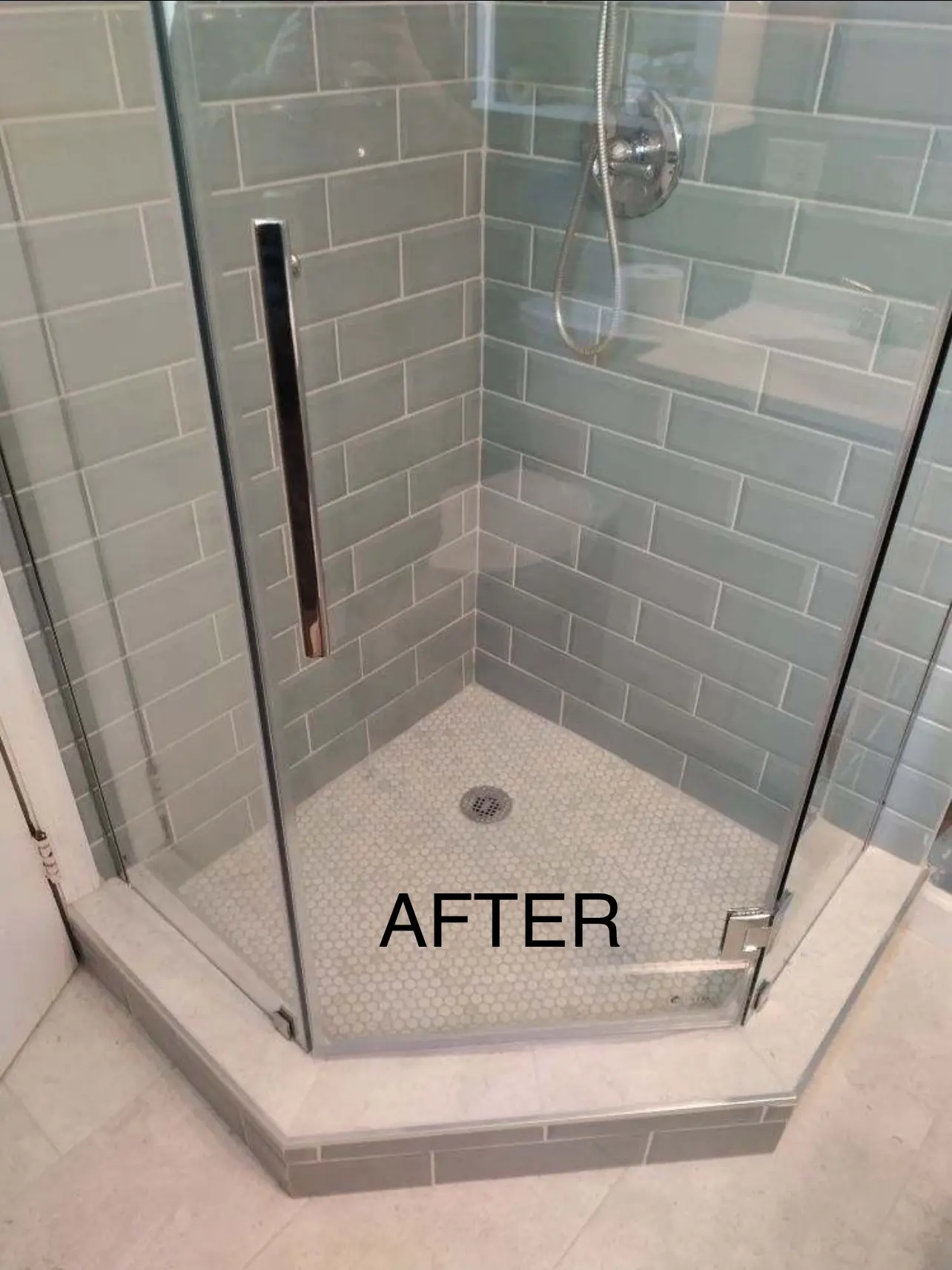Renovated shower with glass door and tiles.
